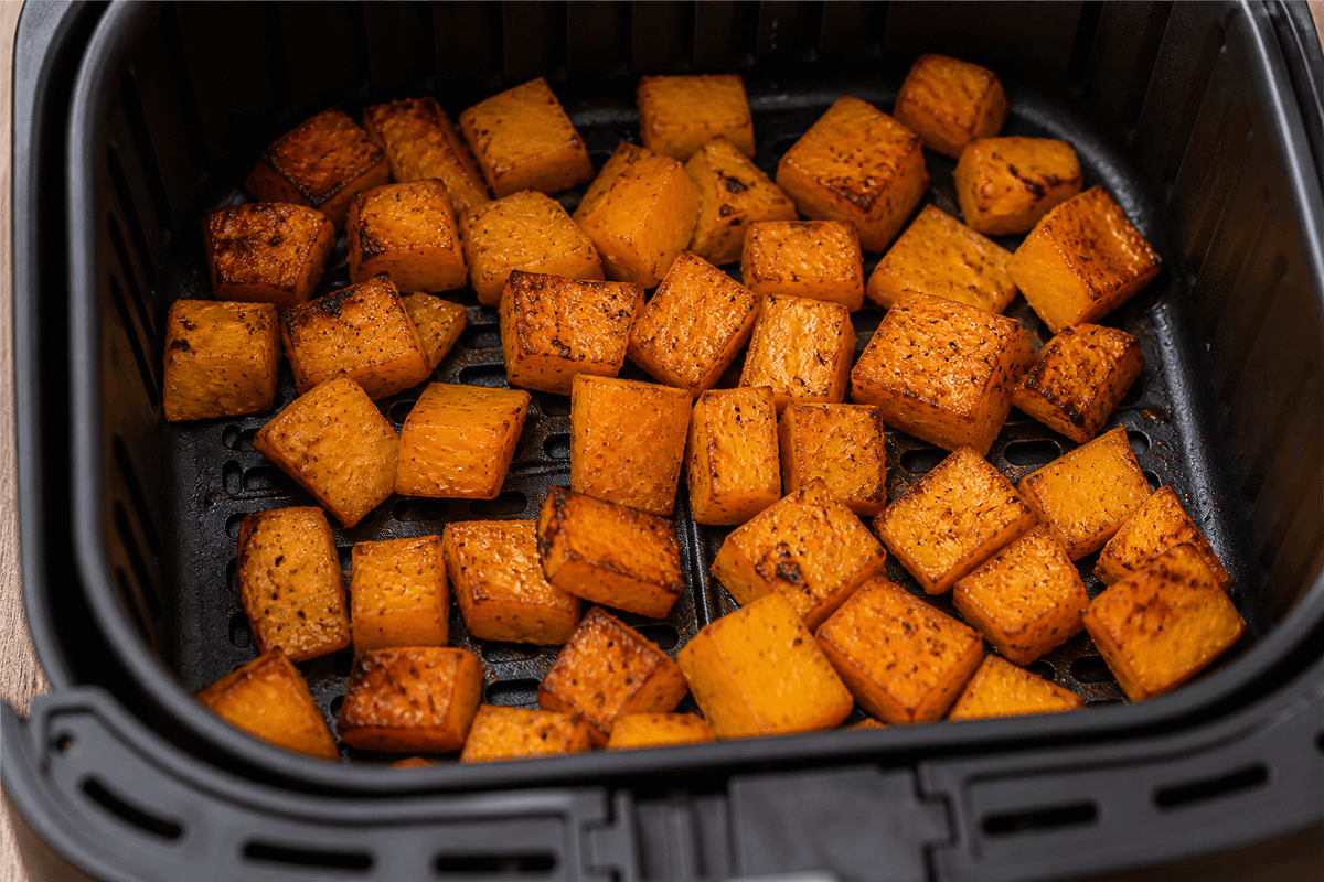 Roasted butternut squash cubes in the air fryer basket