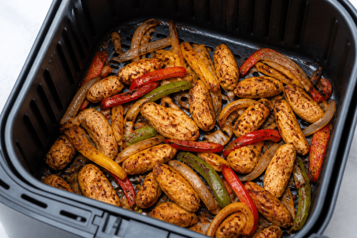 Fajita chicken and peppers cooking in the air fryer basket