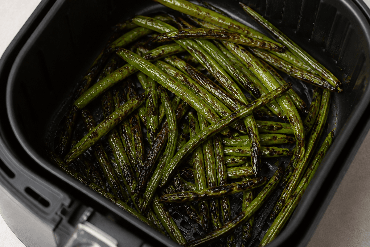 Green beans cooking in the air fryer basket