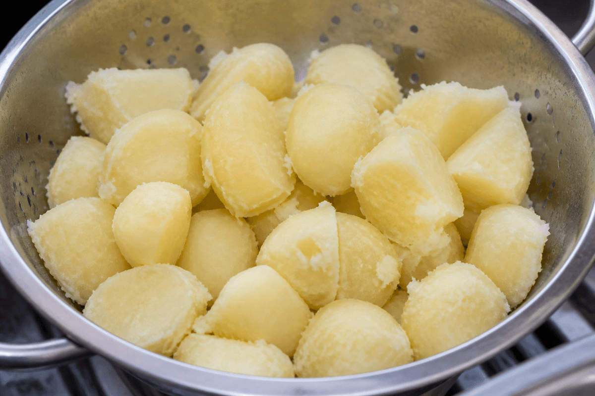 Parboiled potatoes roughed up in a colander