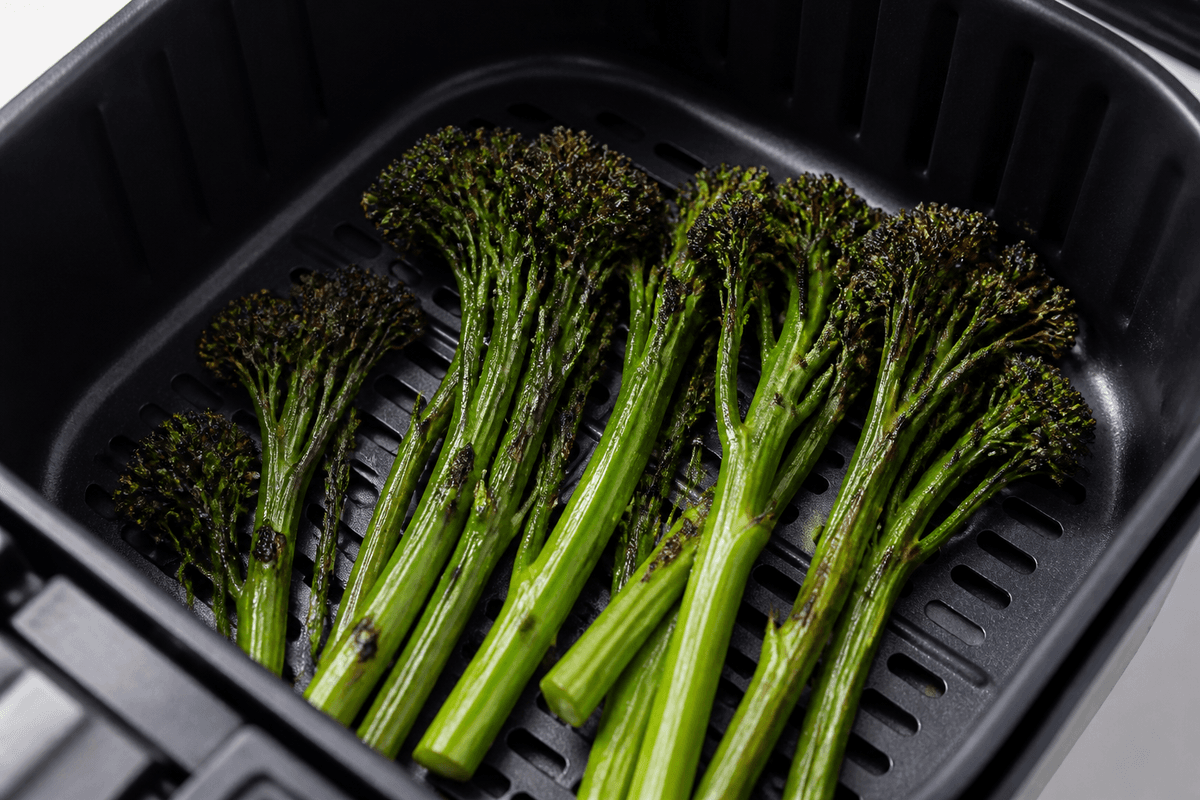 Broccolini roasting in the air fryer basket