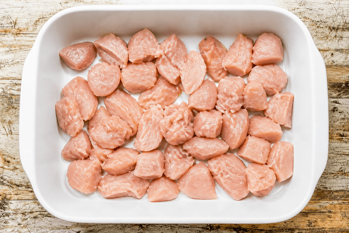Small rough-cut chicken pieces about 1.5 inches with jagged edges on a board