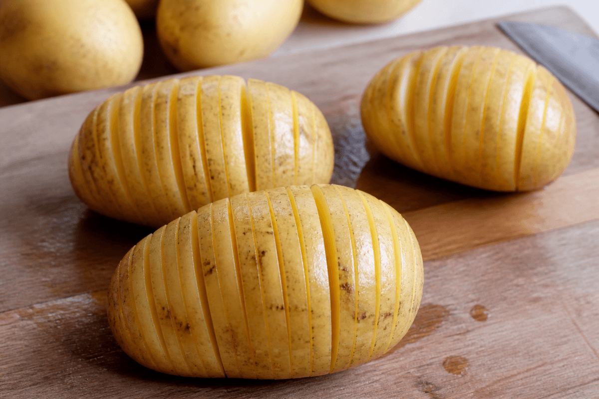 Hasselback potatoes sliced on a board
