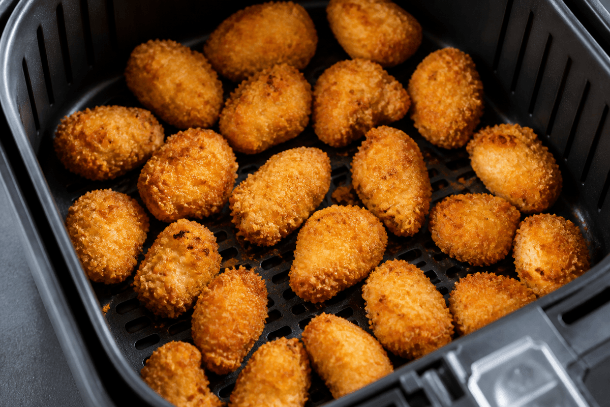 Golden breaded chicken bites in the air fryer basket