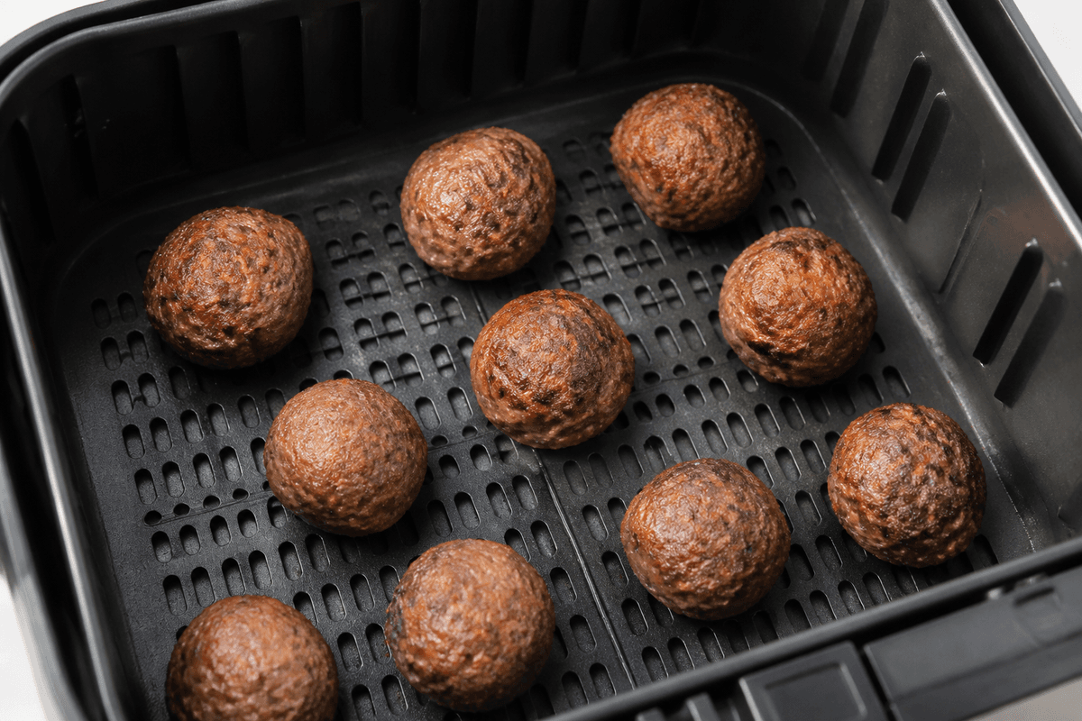 Meatballs browning in the air fryer basket