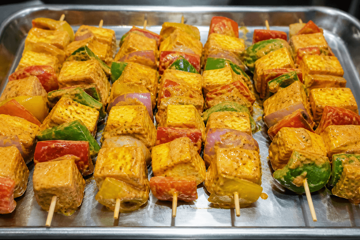 Paneer tikka cubes and peppers on skewers