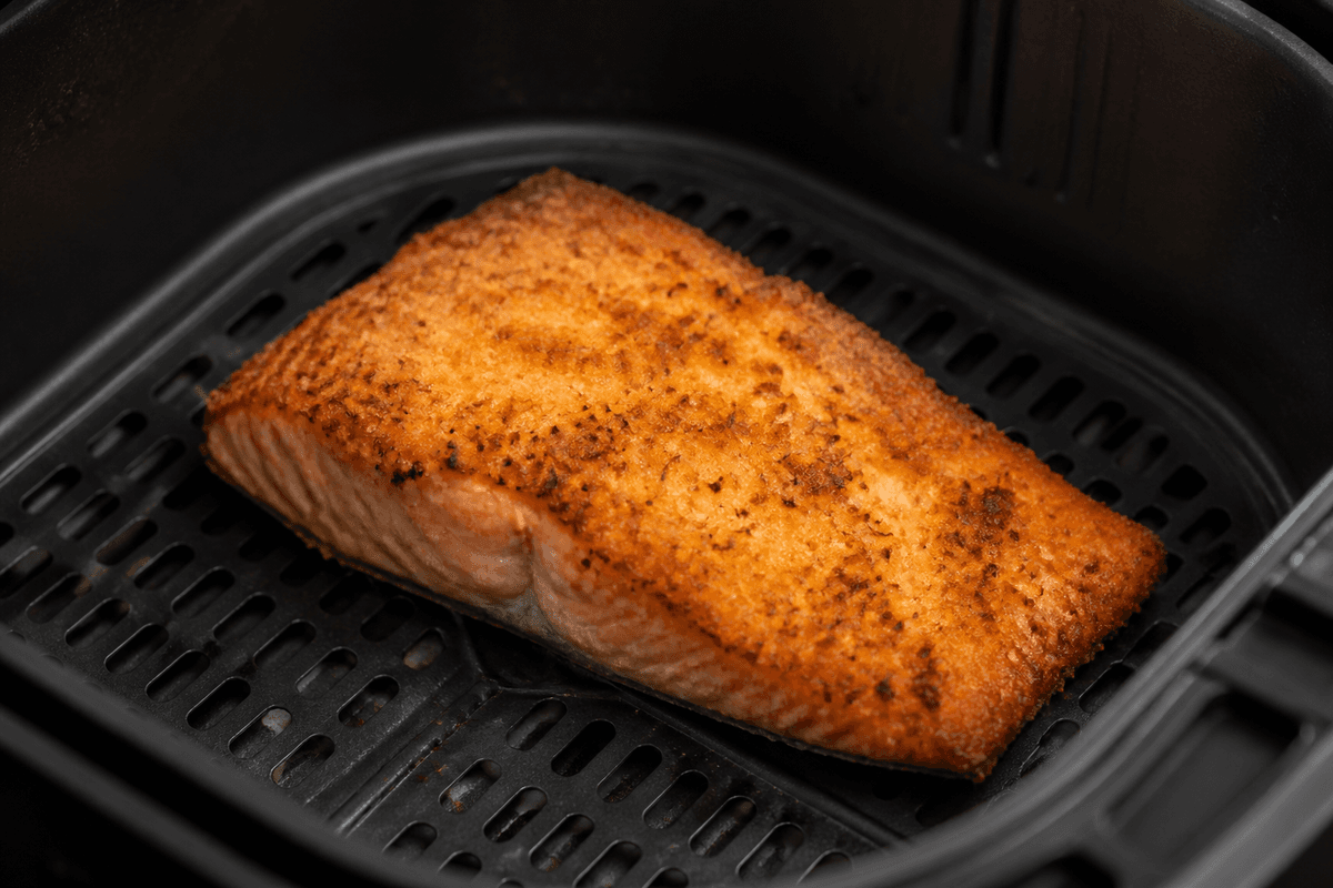 Panko crusted salmon cooking in the air fryer basket